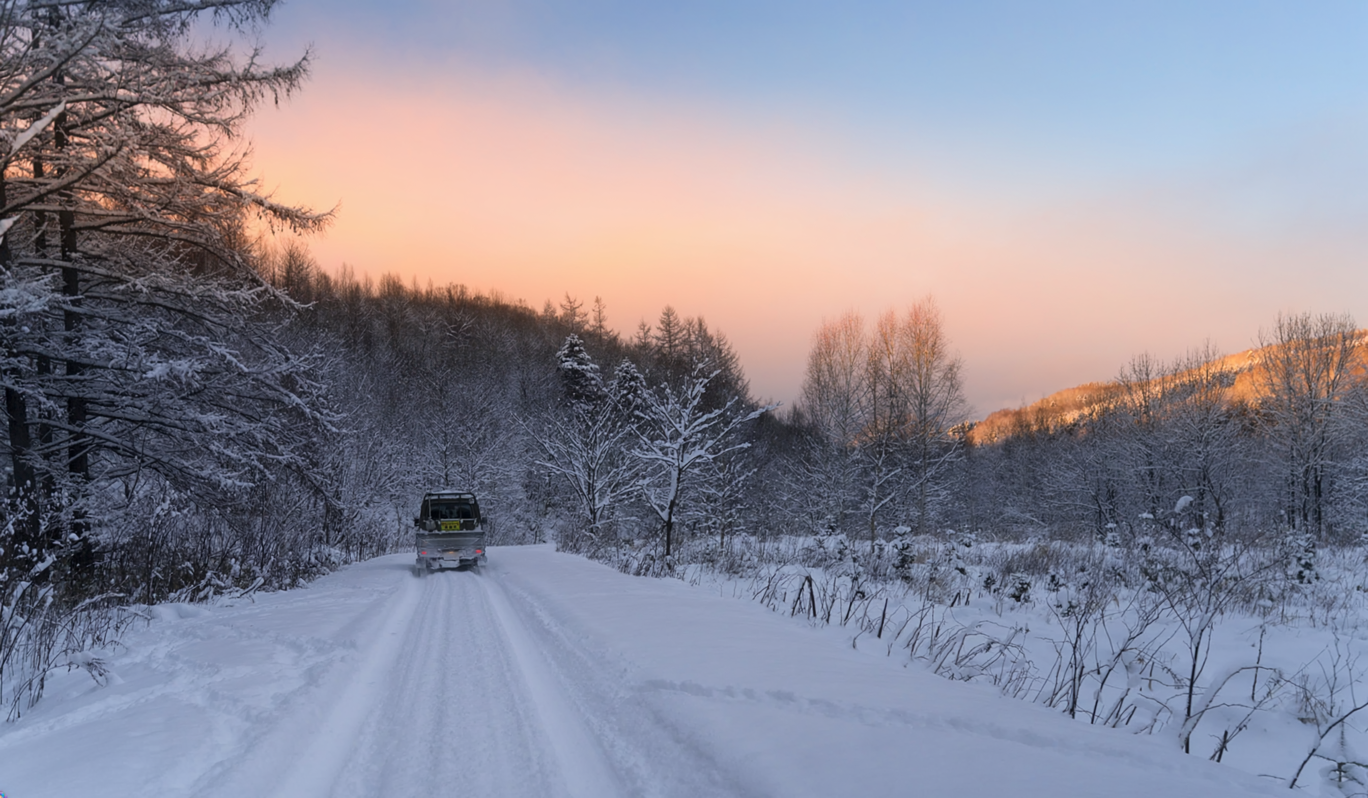 北海道の雪道を進む車両